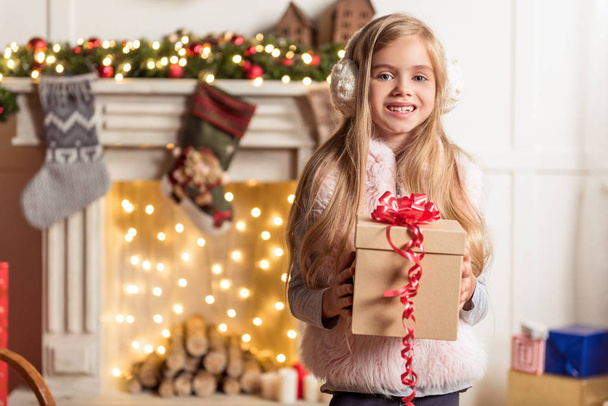 Excited female child keeping holiday gift - 写真・画像