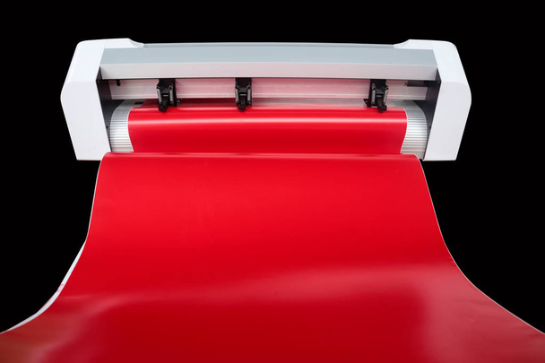 Αυτοκόλλητο μηχάνημα και κόκκινο αυτοκόλλητο φύλλο έτοιμο να κοπή αυτοκόλλητων για χρήση διαφορετικούς τύπους θέσεων εργασίας. - Φωτογραφία, εικόνα
