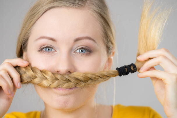 Woman making moustache out of blonde hair - Fotó, kép