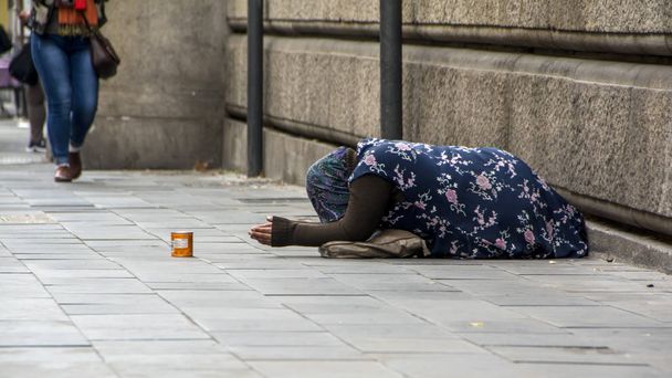 a touching scene with beggar woman on a sidewalk in Rome, Italy - Photo, Image