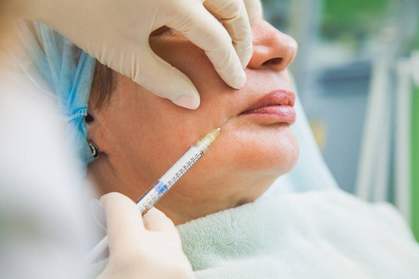 Senior woman cosmetologic injection rejuvenation skin procedure. - Photo, Image
