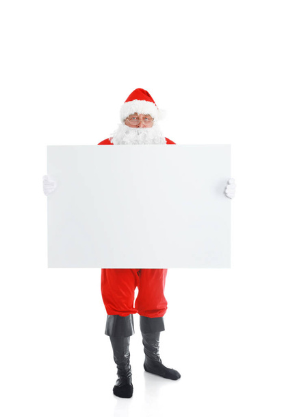 Happy Santa Claus looking out from behind the blank sign isolated on white background - Photo, Image