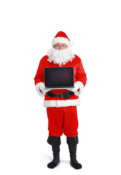 Santa Claus presents a laptop on white background - Foto, afbeelding