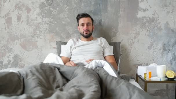 Sick guy in bed blowing his red nose - Séquence, vidéo