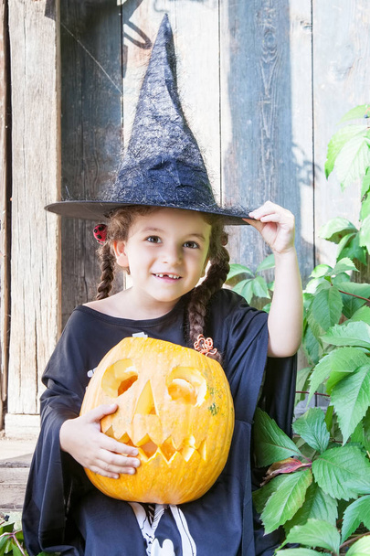 Kleine Hexe mit Halloween-Kürbis - Foto, Bild