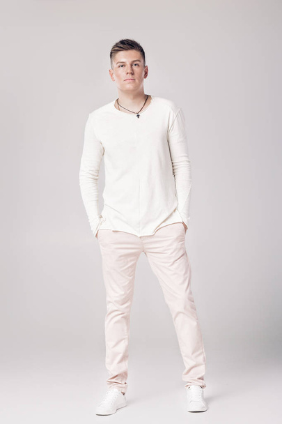 handsome young man in a white sweater and pants - Fotografie, Obrázek