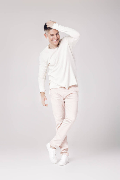 handsome young man in a white sweater and pants - Fotó, kép