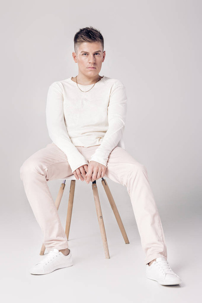handsome young man in white sweater sits on a chair on - Photo, image