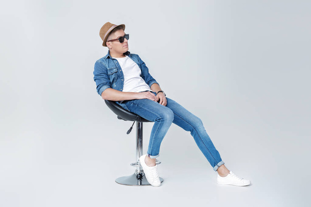 handsome man in denim sits on chair - Photo, image