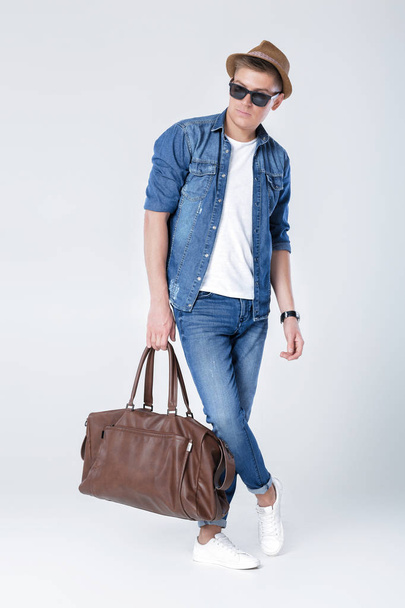 man in denim holding leather bag - Φωτογραφία, εικόνα