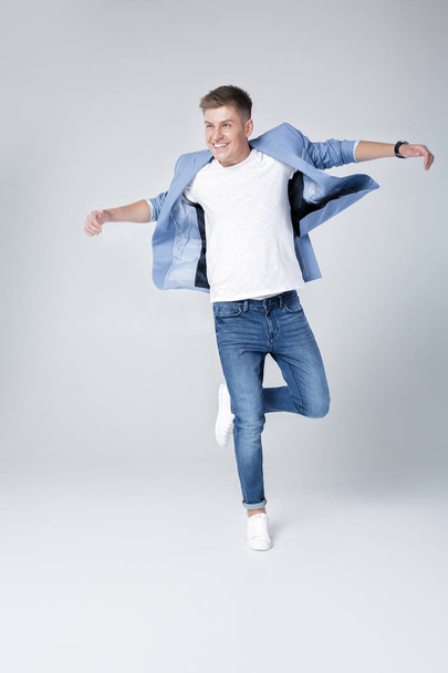 handsome man in jeans and jacket jumping - Foto, afbeelding