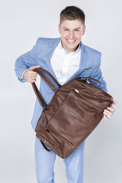 fashion young man in blue suit carrying leather bag - Fotó, kép