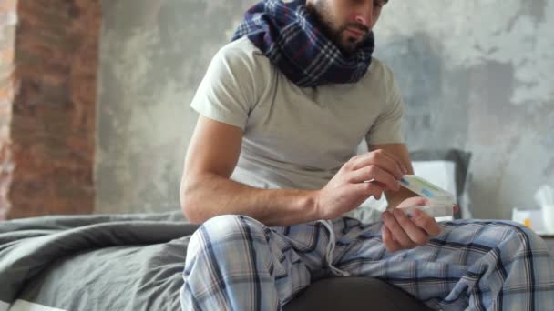 Frustrated guy taking pill from weekly organizer - Filmmaterial, Video