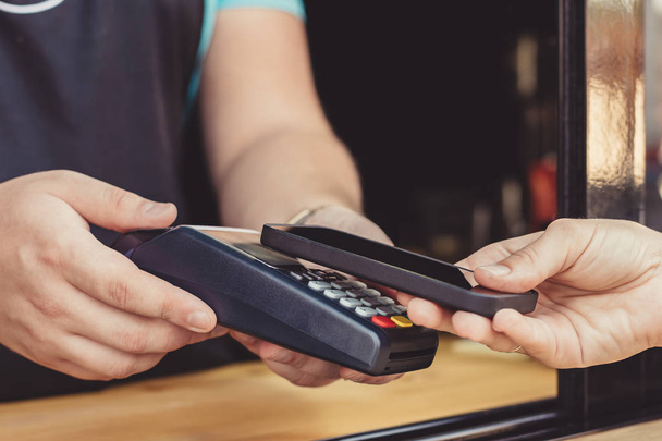 Person paying pay through smartphone using NFC - Φωτογραφία, εικόνα