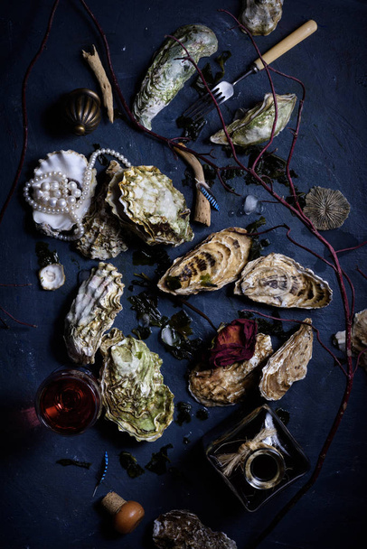 Arrangement of fresh oysters on blue countertop. - Fotó, kép