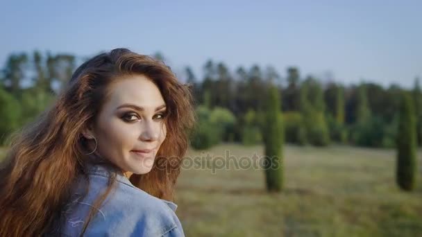 Невероятная и невероятно привлекательная женщина в джинсовой куртке, пересекающая поле одна, но очень счастливая, так что она дает тебе этот потрясающий взгляд
 - Кадры, видео