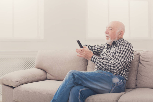 Emotional senior man watching tv copy space - Photo, Image