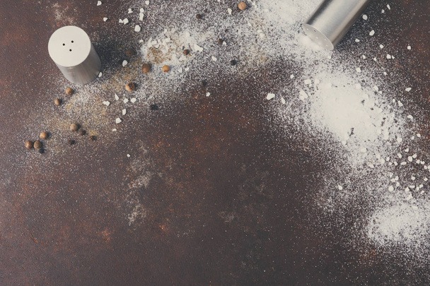 Scattered salt and pepper on dark background - Foto, afbeelding