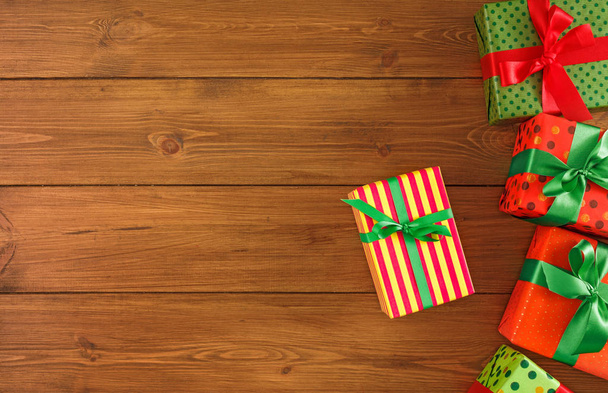 Σύνορα της χρωματιστά πακέτα με κόκκινο, πράσινο κορδέλες για τα Χριστούγεννα, ημέρα του Αγίου Βαλεντίνου ή γενέθλια. Το Top view, αντίγραφο χώρου - Φωτογραφία, εικόνα