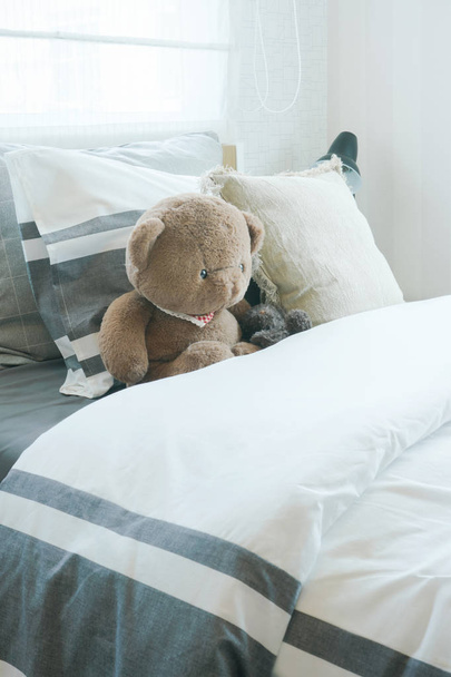 Brown bear and pillows on bed in child's bedroom - Fotografie, Obrázek