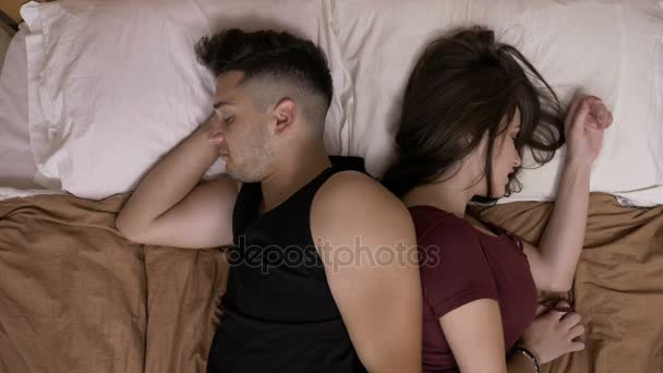 Stressed married couple laying in bed back to back trying to sleep after an argue - Filmati, video