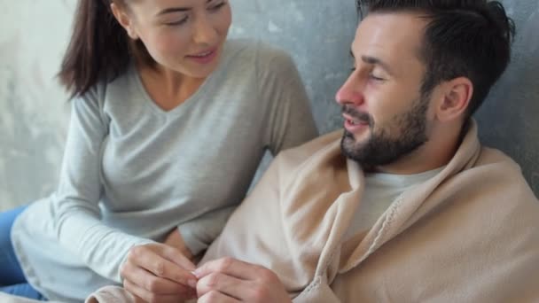 Close up of ill man letting his wife thermometer - Footage, Video