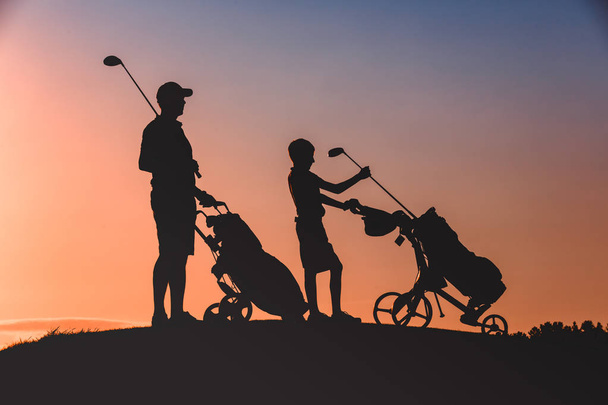 Мужчина со своим сыном силуэт гольфистов
 - Фото, изображение