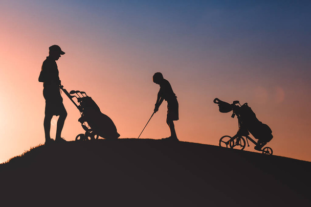 Mann mit seinem Sohn Golfer Silhouette - Foto, Bild