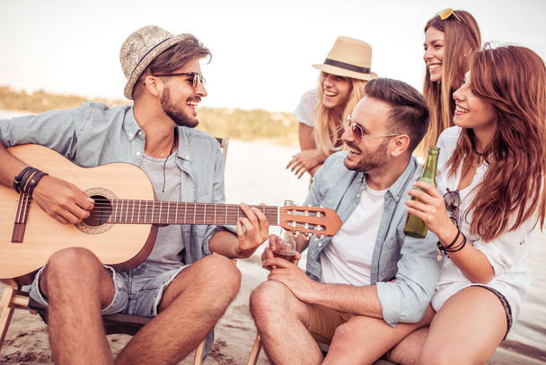 Freunde feiern und Musik hören am Strand - Foto, Bild