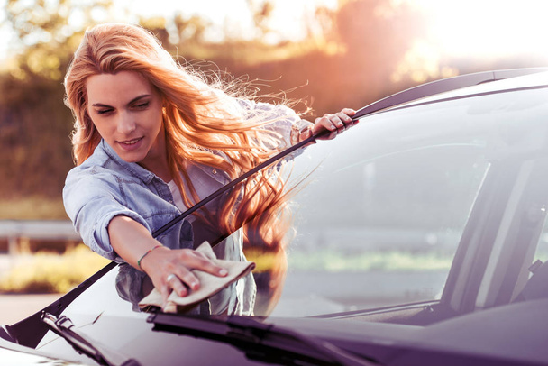 Frau reinigt Auto mit Mikrofasertuch  - Foto, Bild