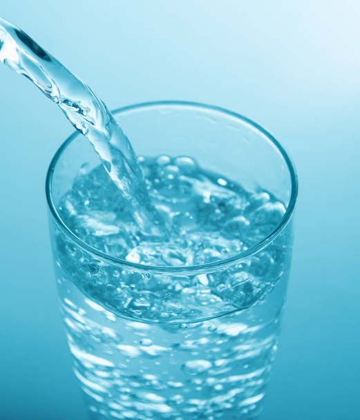verser de l'eau dans du verre fond bleu
 - Photo, image
