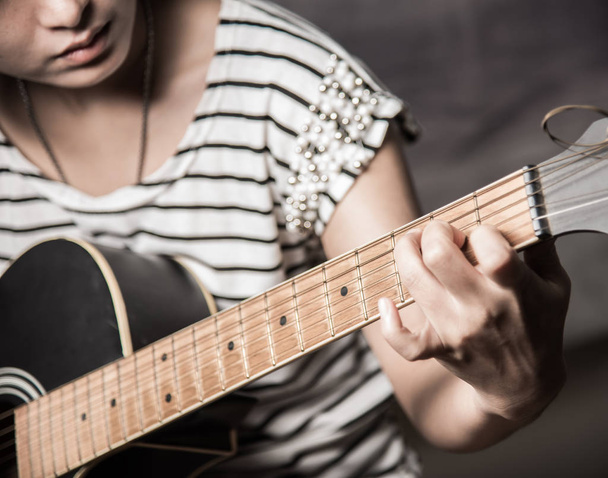 ギターを練習している若い女性は - 写真・画像