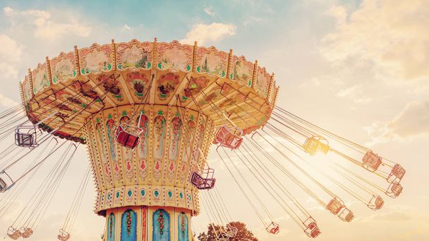 karuselli ratsastaa pyörii nopeasti ilmassa auringonlaskun - vintage suodatin vaikutuksia
 - Valokuva, kuva