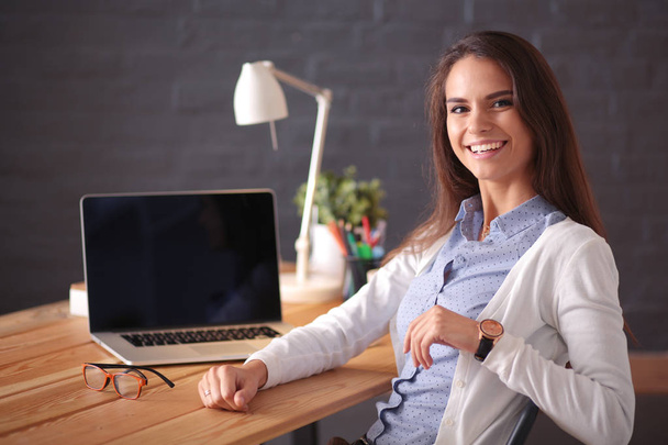 Young female working sitting at a desk. - Фото, изображение