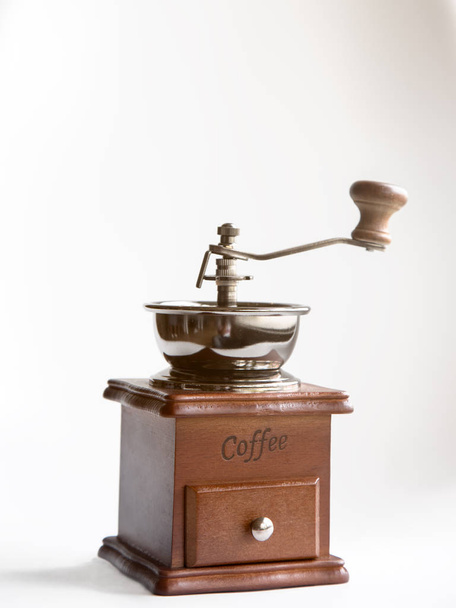 Παλιά ρετρό Μύλος καφέ σε άσπρο φόντο, vintage χέρι-μύλος με θερμό φως αναλαμπής - Φωτογραφία, εικόνα