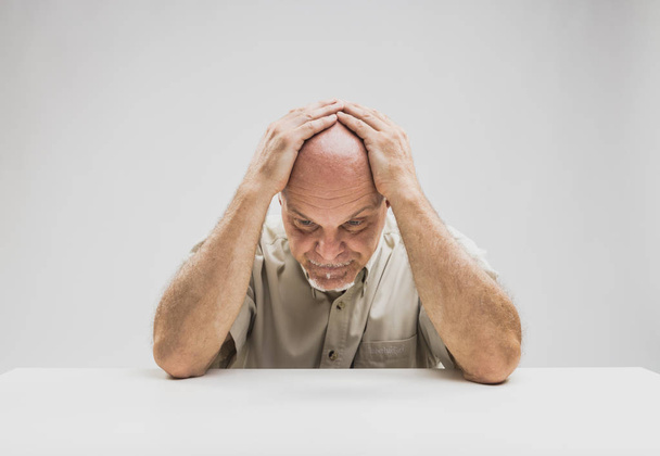Депрессивный человек сидит за столом
 - Фото, изображение