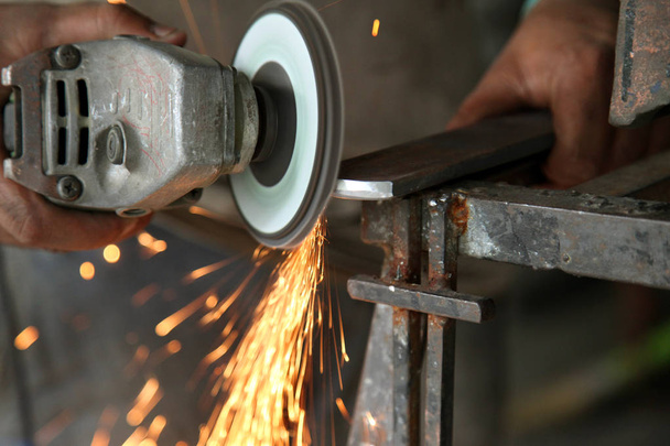 Trabajos de metal. Molienda de rueda eléctrica en la estructura de acero en fábrica
 - Foto, imagen