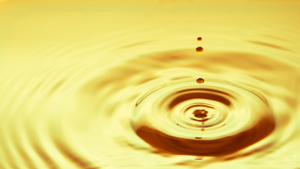 gota de agua de oro cayendo sobre fondo blanco
 - Foto, imagen