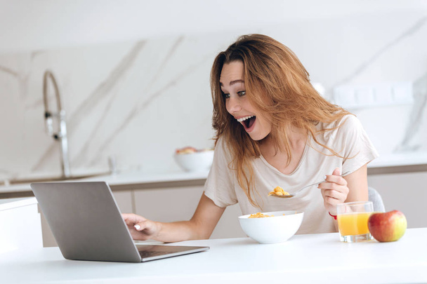 Happy surprised woman chatting on laptop - Foto, Imagen
