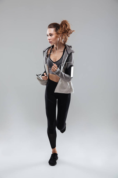 Full length image of a young sports woman running - Photo, Image