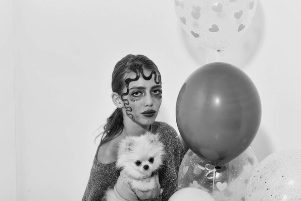 Pretty girl with cute pomeranian dog and party balloons - Fotó, kép