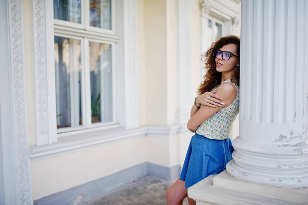 Curly stylish girl wear on blue jeans skirt, blouse and glasses  - Foto, imagen