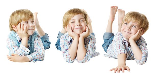 Ευτυχισμένο παιδί, μικρό παιδί αγόρι ψέματα κάτω στο στομάχι, χέρι στο πηγούνι, λευκό απομονωμένες - Φωτογραφία, εικόνα