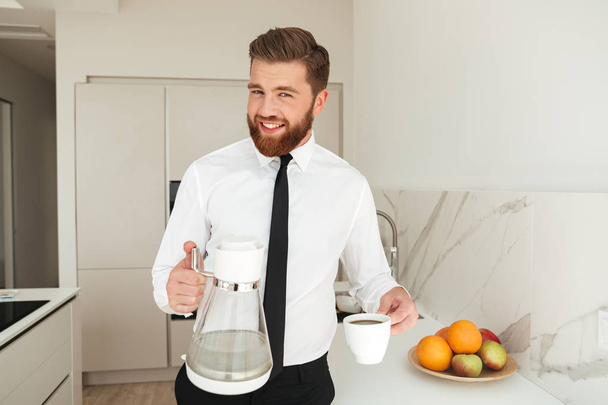 Happy bearded business man pours a coffee - Fotoğraf, Görsel