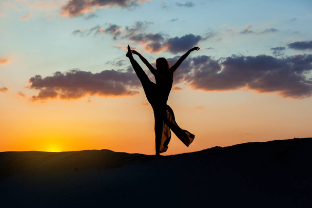 Жінка танцює на заході сонця
. - Фото, зображення
