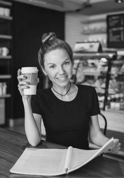 Woman with copybook and cup of coffee, black and white - Foto, Imagen