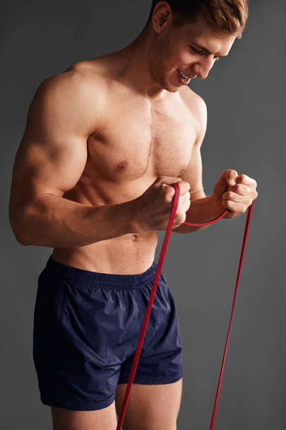 Strong man with elastic band - Фото, изображение