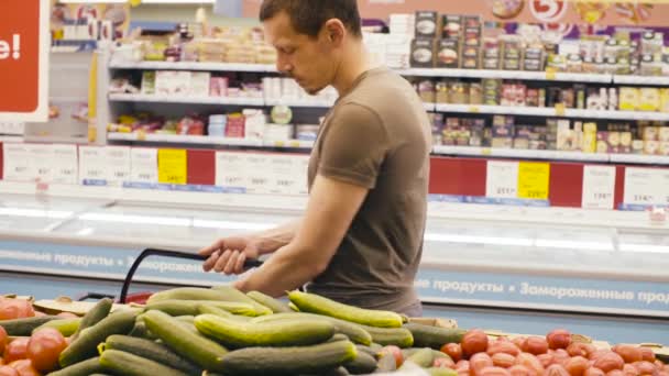 Bir adam bir süpermarkette sebze seçme - Video, Çekim