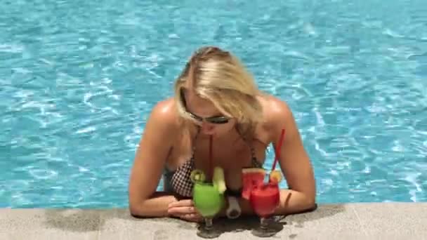 Krásná žena v bazénu pije tropické koktejly. - Záběry, video
