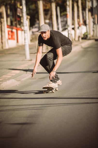 Skateboarder ride a skateboard slope through the city street - 写真・画像